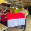 Bhabinkamtibmas Polsek Tenggarong Sambangi Warga, Bagikan Bendera Merah Putih Jelang HUT ke-81 RI