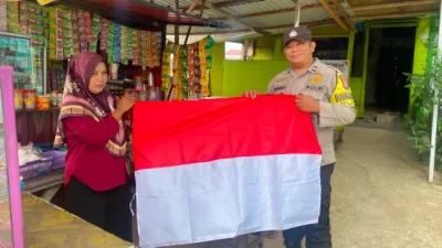 Bhabinkamtibmas Polsek Tenggarong Sambangi Warga, Bagikan Bendera Merah Putih Jelang HUT ke-81 RI
